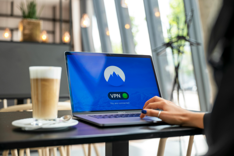 Woman using NordVPN on laptop in coffee shop